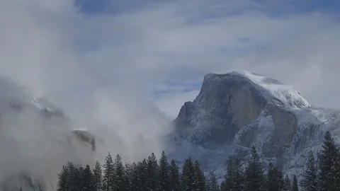 Snowy Half Dome with Tree Line and Clouds Rolling In Stock Footage 122400645