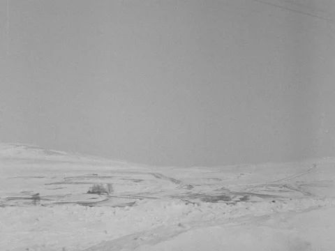 Snowy landscape with freight train stuck in snowdrift, UK 1955 Stock Footage 133270476