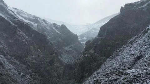 Snowy mountain gorge with dramatic cliffs in winter nature landscape Stock Photos