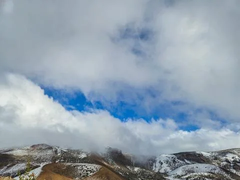 Snowy mountain landscape beneath dramatic cloud cover 写真素材