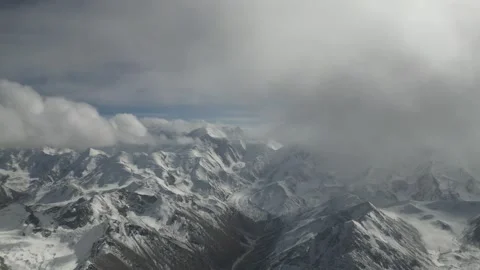 Snowy mountain landscape with clouds, camera pans across the scene Video stock 325024201