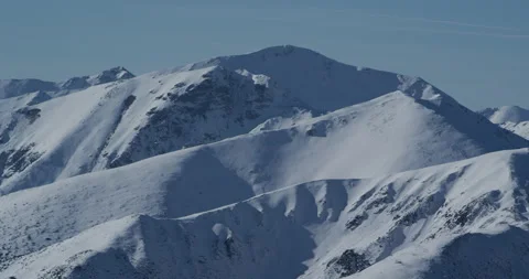 Snowy mountain landscape with low sun and blue sky. Stock Footage 147643245
