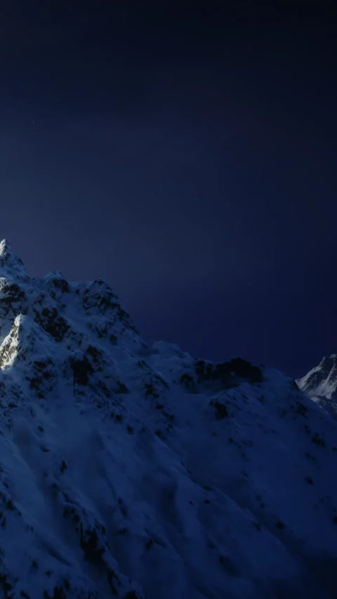 Snowy mountain landscape at night with moonlight casting shadows Stock Footage 339043084