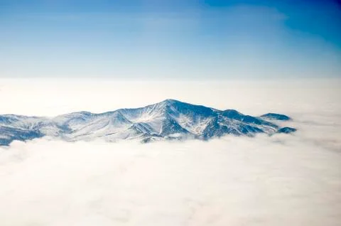 Snowy mountain over the clouds Stock Photos