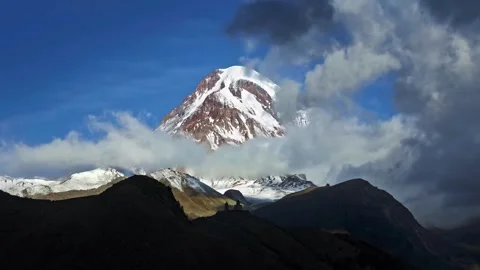 Snowy mountain peak emerging from moving clouds Stock Footage 340962928