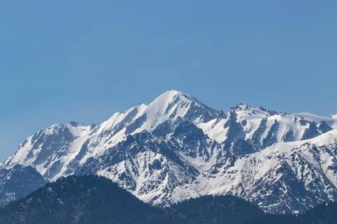 Snowy mountain peaks on a clear sunny day Stock Photos