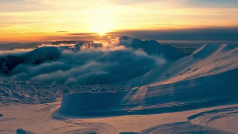 Snowy mountain peaks at sunrise with dramatic clouds and golden light. Stock Footage 341396438