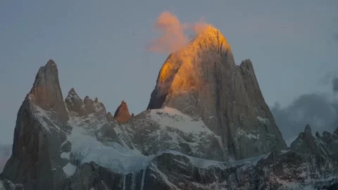 Snowy mountain peaks at sunrise with dramatic clouds and golden light. Stock Footage 341992315