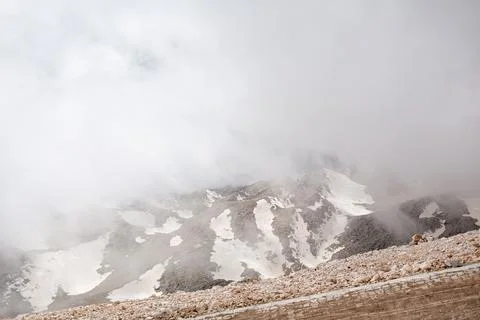 Snowy mountain peaks surrounded with clouds Stock Photos