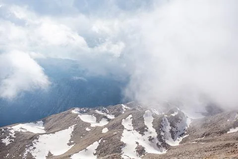 Snowy mountain peaks surrounded with clouds Stock Photos
