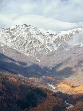 Snowy Mountain Peaks Tower Over Autumn Valley Stock Photos