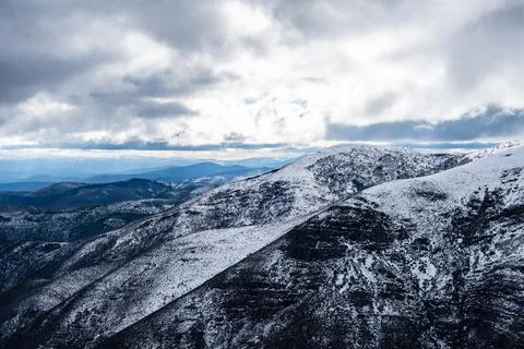 Snowy mountain peaks under dramatic winter sky Stock Photos