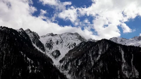 Snowy mountain peaks under moving clouds during a scenic alpine winter afte.. Video stock 337684199