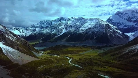 Snowy mountain range and green valley with river stream Stock Footage 340962860