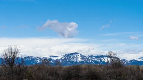 Snowy mountain range in spring with clouds rolling off Stock Footage 167060831