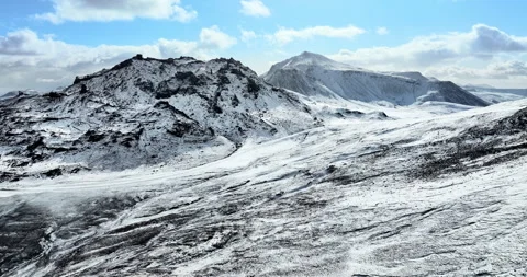 Snowy mountain range under blue sky in Iceland. Epic aerial winter landscape. Stock Footage 242069435