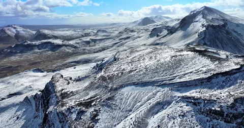 Snowy mountain range under blue sky in Iceland. Epic aerial winter landscape. Stock Footage 242069868