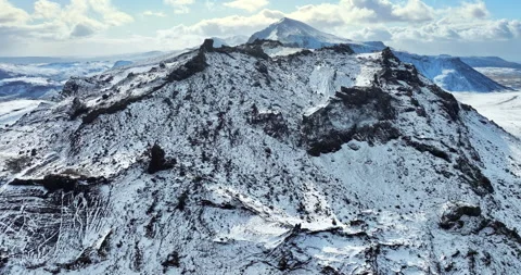 Snowy mountain range under blue sky in Iceland. Epic aerial winter landscape. Stock Footage 242070139