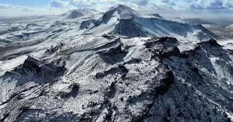 Snowy mountain range under blue sky in Iceland. Epic aerial winter landscape. Stock Footage 242070216