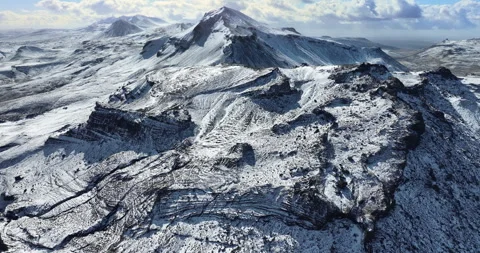 Snowy mountain range under blue sky in Iceland. Epic aerial winter landscape. Stock Footage 242070623