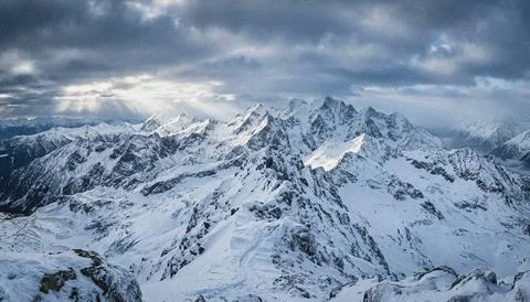 Snowy mountain range under cloudy sky. Stock Illustration