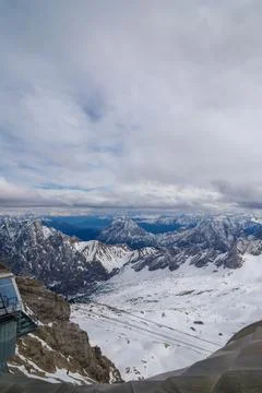 Snowy Mountain Range View with Building and Cloudy Sky Stock Photos
