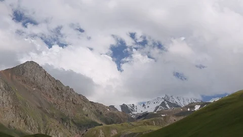 Snowy mountain ranges and clouds in summer Stock Footage 87750413