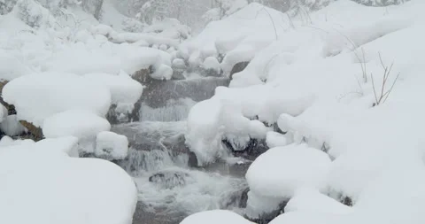 Snowy Mountain River Flowing Through Rocks in Winter Stock Footage 325682636