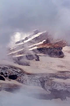 Snowy mountain side through thick cloud cover Stock Photos