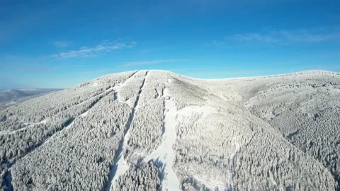 Snowy mountain with ski slope, trees and beautiful sky in winter Stock Footage 226365913