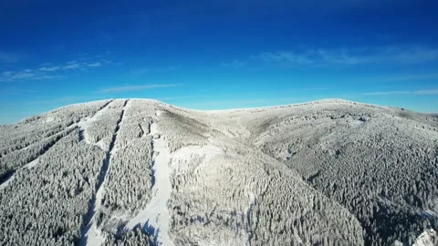 Snowy mountain with ski slope, trees and beautiful sky in winter Stock Footage 226366245