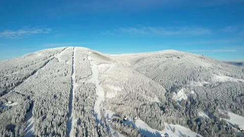 Snowy mountain with ski slope, trees and beautiful sky in winter Stock Footage 226366317