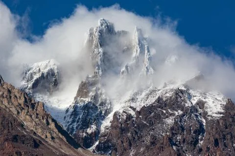Snowy mountain summit in clouds Stock Photos
