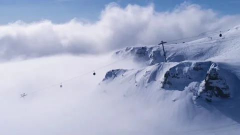 Snowy mountain valley with clouds. High altitude ski gondola in winter. Stock Footage 150680026