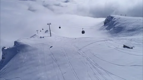 Snowy mountain valley with clouds. High altitude ski gondola in winter. Stock Footage 150680051