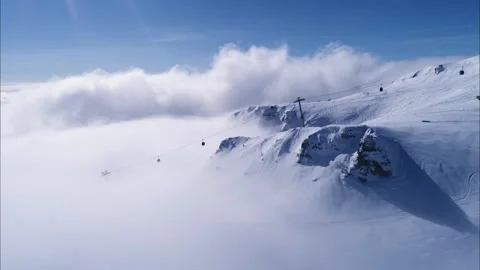 Snowy mountain valley with clouds. High altitude ski gondola in winter. Stock Footage 150680086