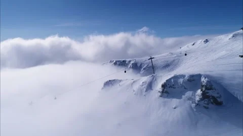 Snowy mountain valley with clouds. High altitude ski gondola in winter. Stock Footage 150680098