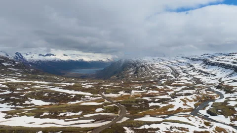 Snowy mountain valley with winding road and distant peaks. Iceland Stock Footage 337319010
