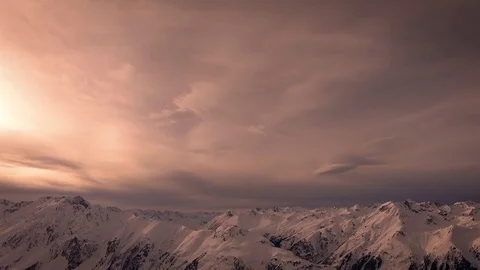 Snowy mountains and clouds time lapse with yellow orange and red warm sunlight. Stock Footage 85325052