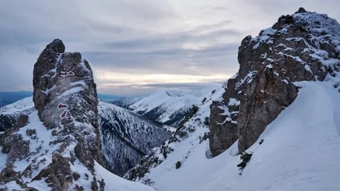 Snowy mountains and white clouds, cloudy sunset. Snow blown rocks, hiking signs Stock-Footage 169597085