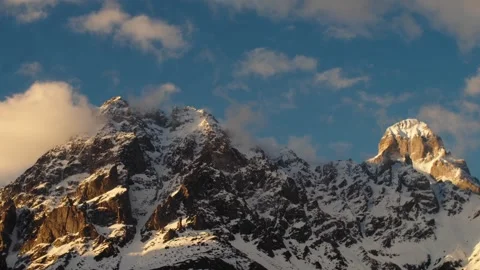 Snowy mountains covered with clouds time lapse video. Beautiful view of the Stock Footage 258206194
