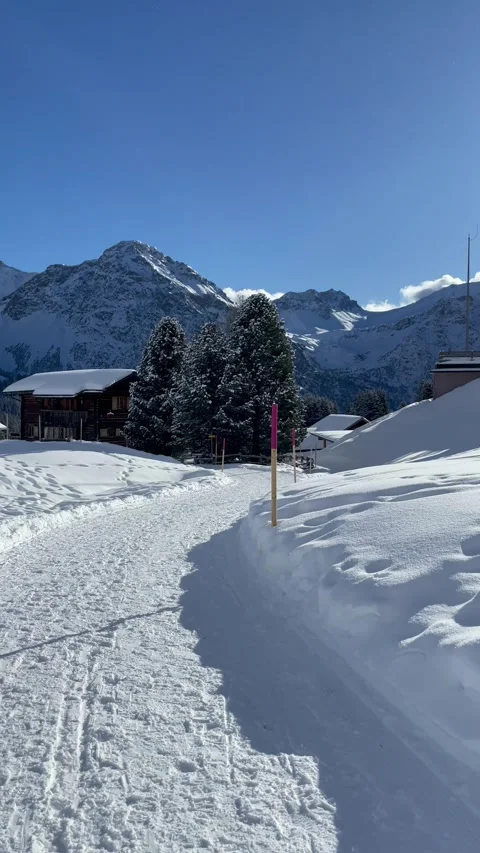 Snowy mountains under blue sky with Swiss chalet Video stock 330585307