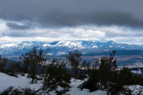 Snowy mountains under dramatic cloudy sky winter landscape Stock Photos