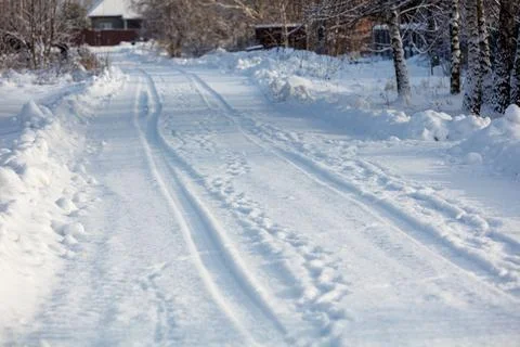 Snowy path winds through quiet, wooded winter landscape Stock Photos