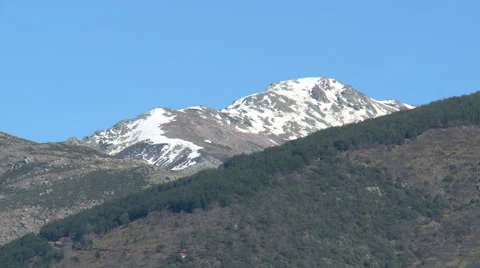 Snowy peak behind slopes full of forests Stock Footage 49652270