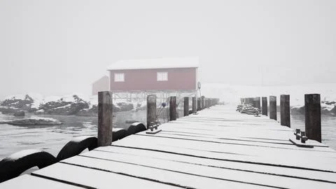 Snowy Pier With Red Building in Norwegian Sea Ilustración de archivo