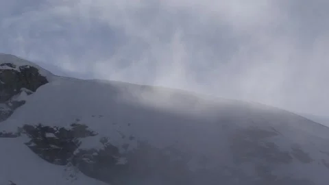 A snowy ridge with light clouds passing by Stock Footage 303588898