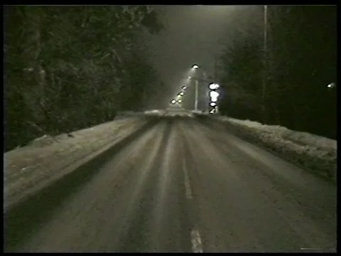 Snowy Road at Night With Distant Lights Stock Footage 336300712