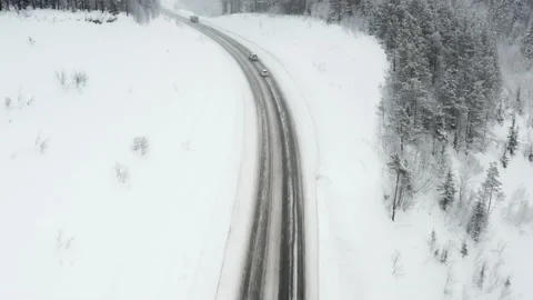 Snowy road runs through the forest in the mountains . Video stock 169264665