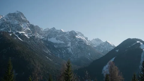 Snowy rocky mountain range forest panning handheld shot Stock Footage 341340567